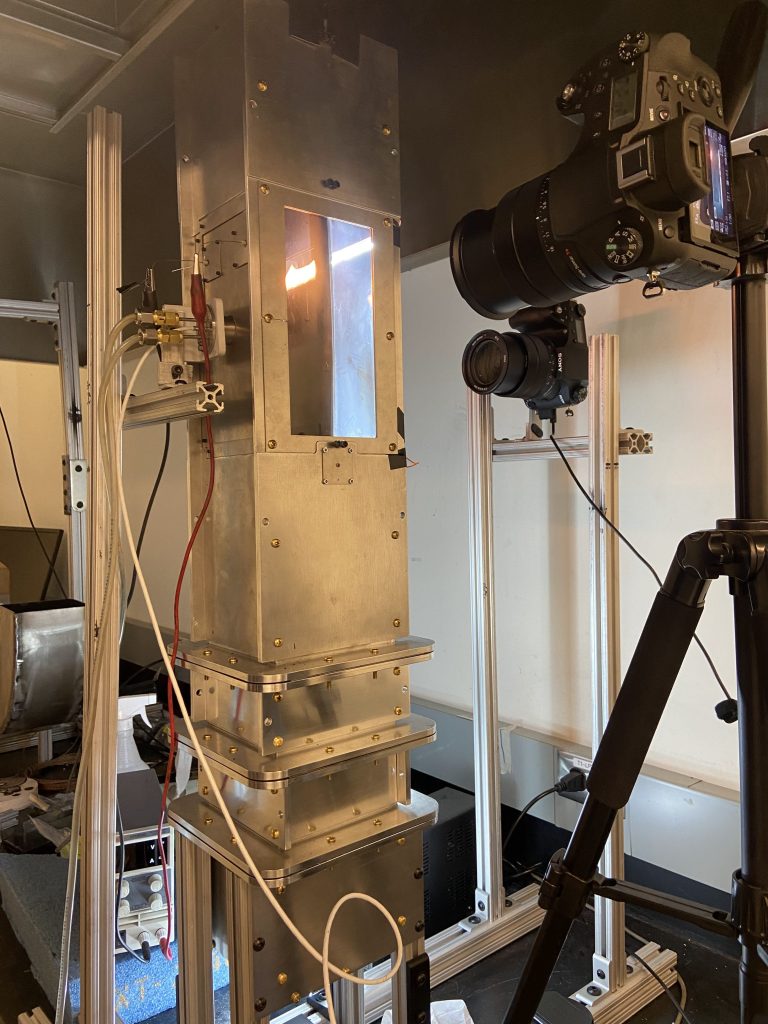 Downward opposed flame spread response to non-steady airflow