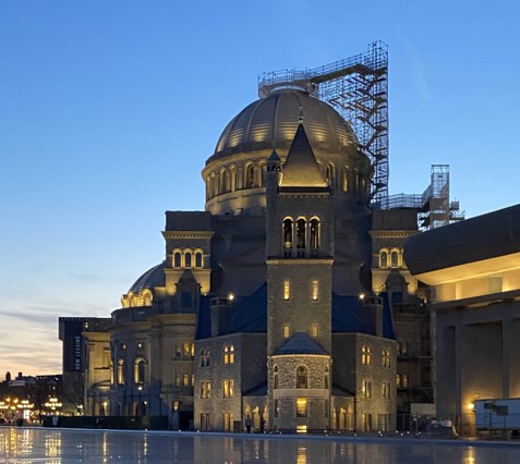 Illuminated domed historic building with scaffolding at dusk