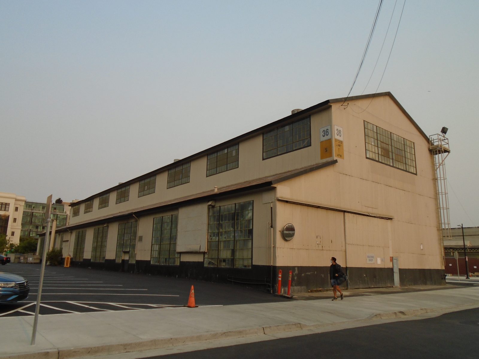 Industrial warehouse with large windows, marked building 36, beside a paved parking area