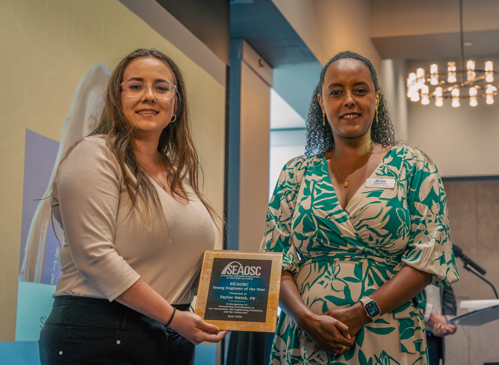 Two women hold a SEAOSC Young Engineer of the Year award presented to Taylor Walsh, PE, in June 2026
